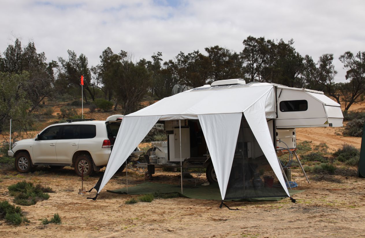 A Kimberley camper with its awning extended at a bush campsite beside a four-wheel drive