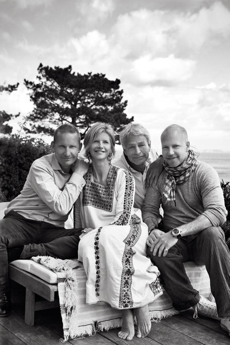 A black and white portrait of four members of the Lynggaard family sitting together outdoors