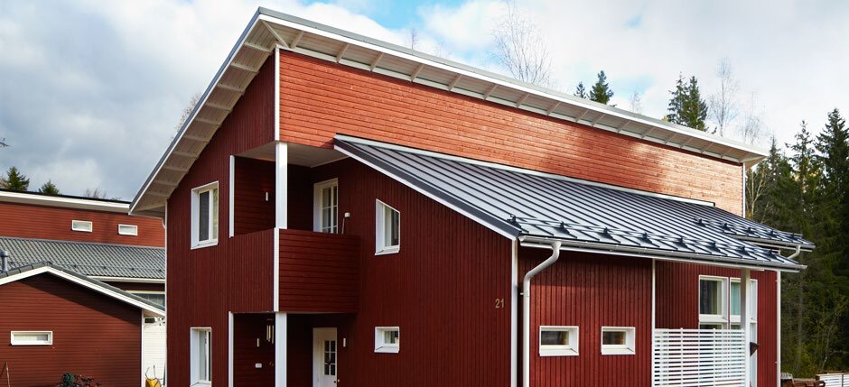 Red timber-clad houses with grey Lindab steel roofing and gutters